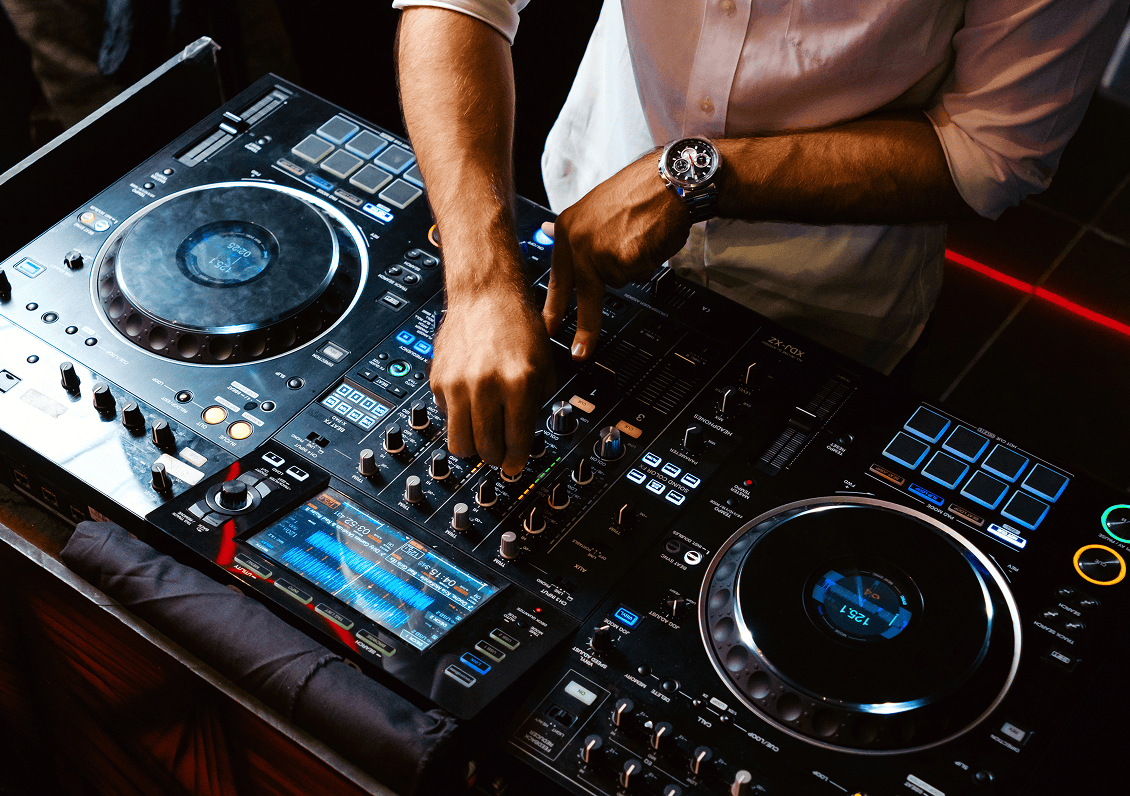 DJ mixing music on professional equipment.