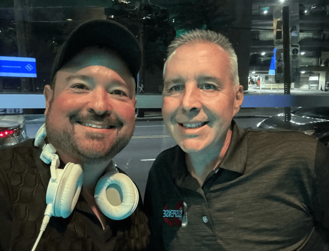 Two men smiling at a restaurant.