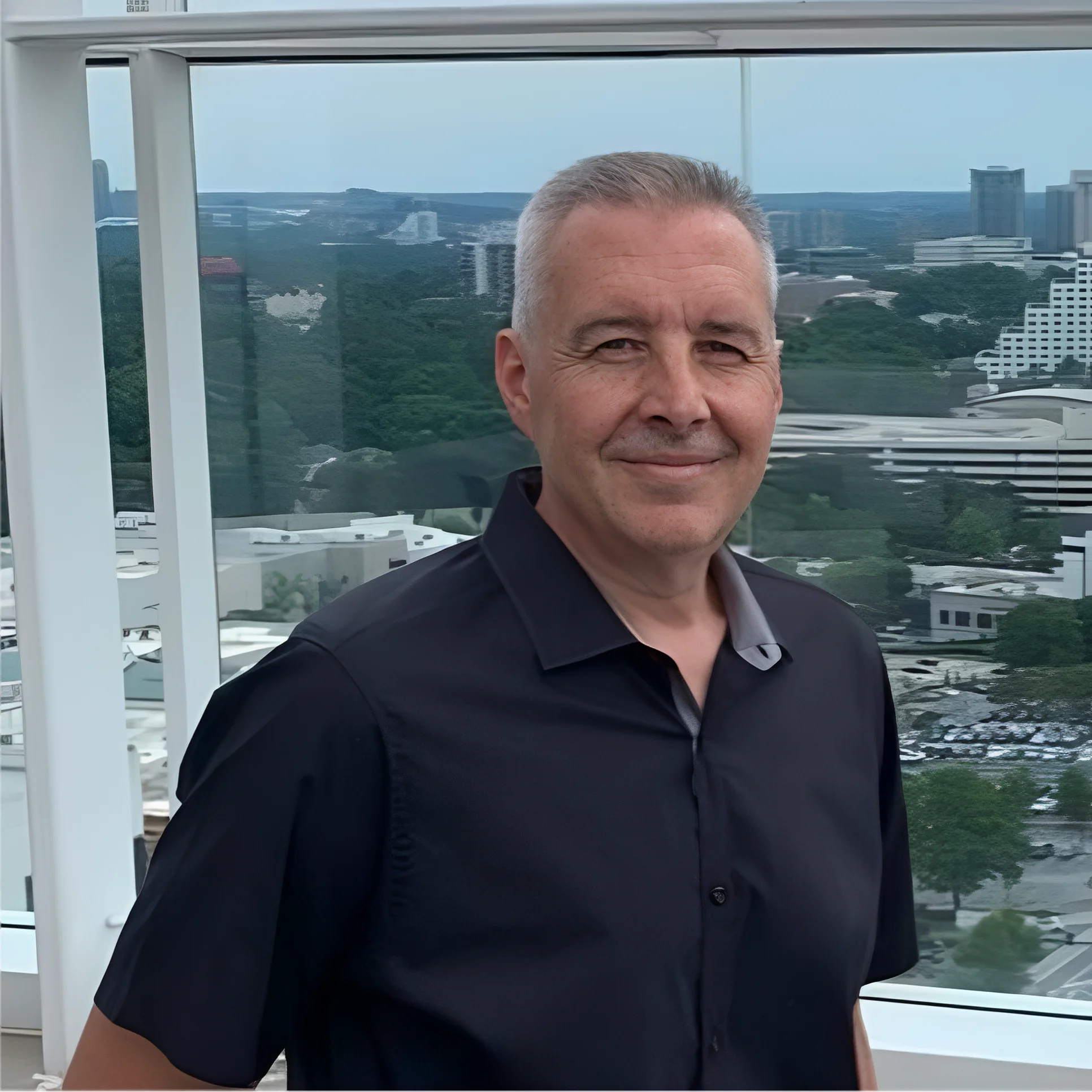 Man smiling with cityscape background.