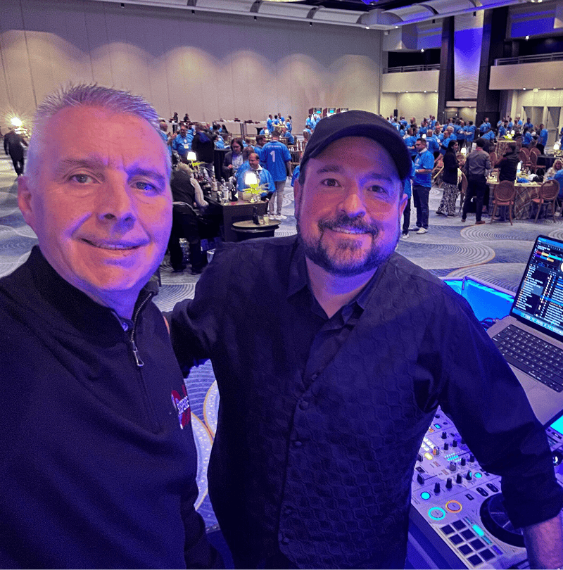 Two men smiling at an event setup.